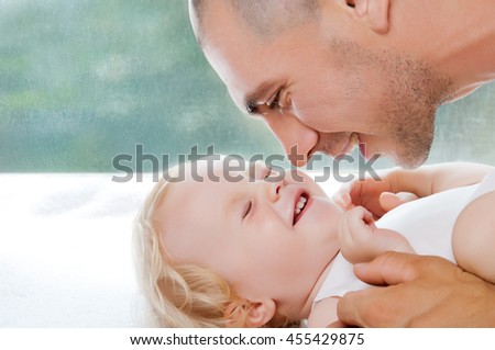 Happy loving family. Father and his baby child playing and hugging. Daddy and his toddler girl. Pastel studio background and space for text.