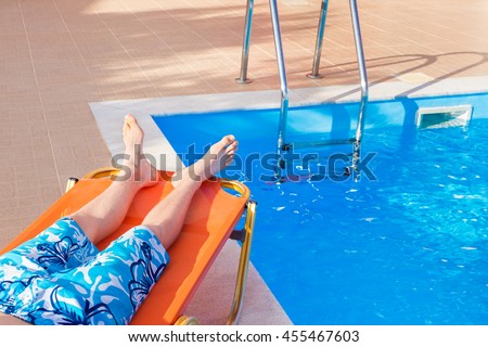 Caucasian teenage boy lying on stretcher near blue swimming pool