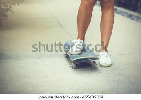 Close-up of teenage girl skateboarding in the park with sunlight
