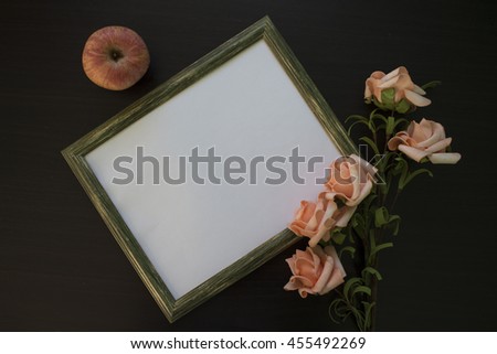 Frame for picture with flowers and apples. Flat lay on table, top view diagonal composition with text place. Rustic natural frame and ornament. Shabby chic photo background. Pink roses and white paper