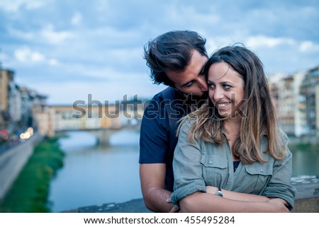 Loving couple embracing at the sunset in front of Ponte Vecchio, Florence 