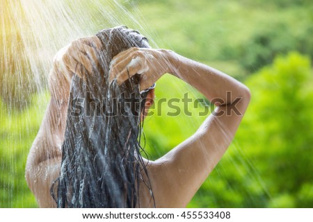 Woman showering and shampooing outdoor Royalty-Free Stock Photo #455533408