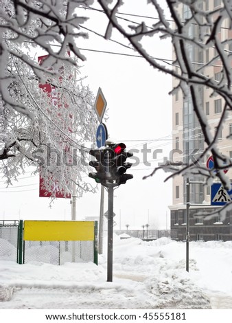 Winter crossroads with traffic lights, snow drifts, road signs