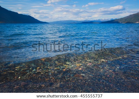 Summer picture of norwegian fjord with water and beach pebbles, Norway, Lofoten Islands