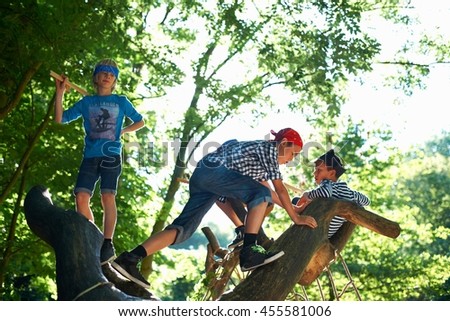 Young boys dressed as pirates, playing in tree