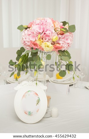 Wedding flowers on table dinner. Flower garland made of pink and white roses lies on a wedding dinner table
