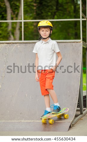 The boy in the cap standing on a skateboard