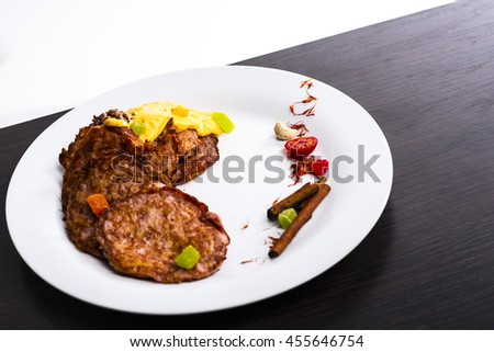 Pancakes and pancakes on a plate on the black-and-white background under the yellow sauce