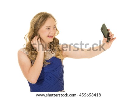 A woman with down syndrome holding out her phone taking a picture, with a big smile