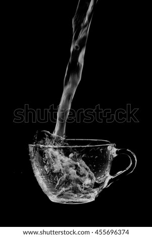 Water splash out of glass on a black background.
