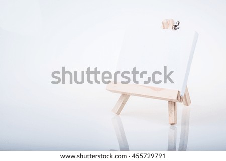 Small easel with a blank canvas over white
