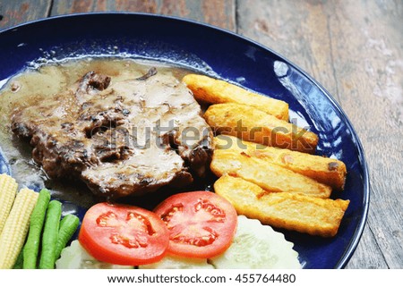 Grilled beef steak with french fries and vegetables. 