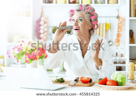 Senior woman in  hair rollers at kitchen