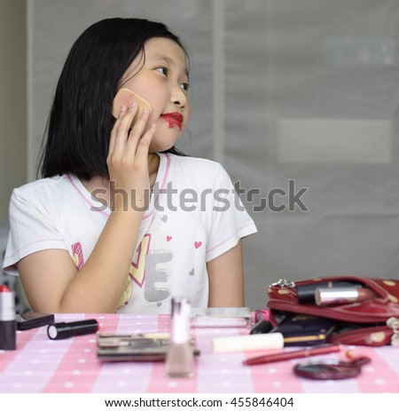 Pretty asian little girl makeup herself