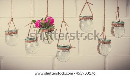 Flowers in jars on a string.