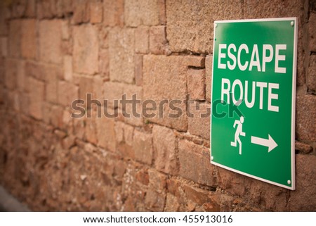 Color image of an Escape Route indicator on a brick wall.