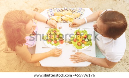 Top view image of mature couple having date in restaurant or cafe. Beautiful people sitting at table and having lunch or dinner. People communicating and happy smiling.