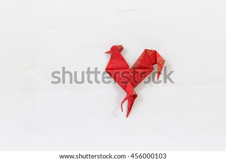 Origami red morning cock on the white background
