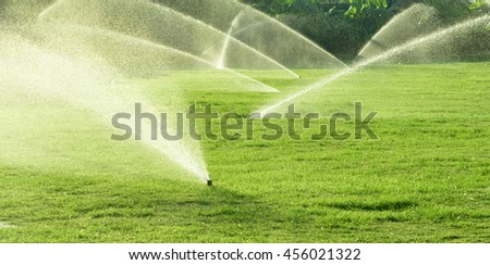 Irrigation System Watering the green grass, blurred background Royalty-Free Stock Photo #456021322