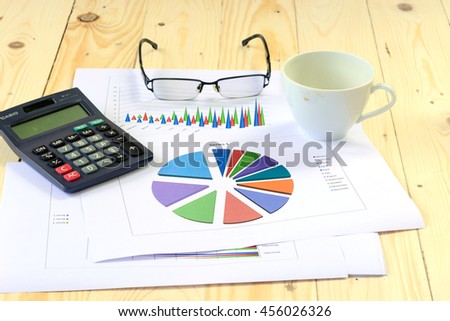 Graph and calculator on a wooden floor in the growth of the business