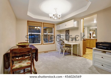 Dining room with antique table set, carpet floor and two big windows