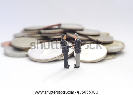 Businessman handshake and business people over money background , miniature people concept.
