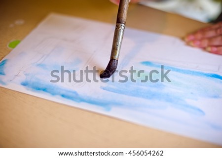Draws the brush on the paper blue, watercolor