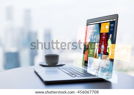 technology, internet, media, business and modern life concept- close up of open laptop computer with news web page on screen and coffee cup on table at office or hotel room Royalty-Free Stock Photo #456067708