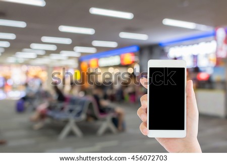 woman use mobile phone and blurred image of people wait in the airport boarding gate