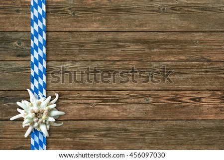 Oktoberfest background with edelweiss and Bavarian ribbon on old wooden 