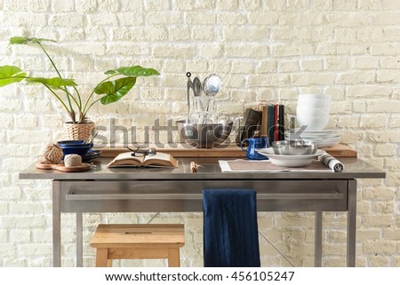 Kitchen brass utensils, chef accessories. Hanging copper kitchen with white tiles wall