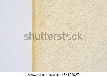 Rough plaster surface texture with border between white and yellow areas