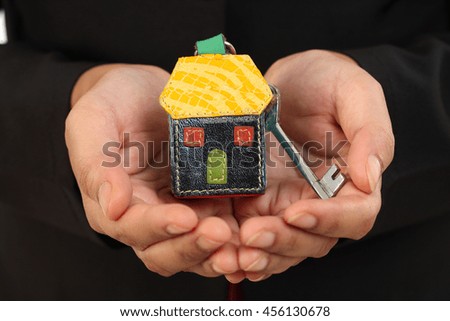 Business woman holding house key against white background
