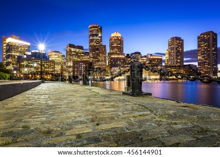 Panoramic view of Boston in Massachusetts, USA at night showcasing the skyscrapers of its Financial District and the Boston Harbor.