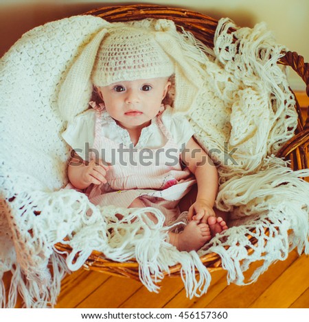lovely girl in a nice hat sitting in a wooden basket