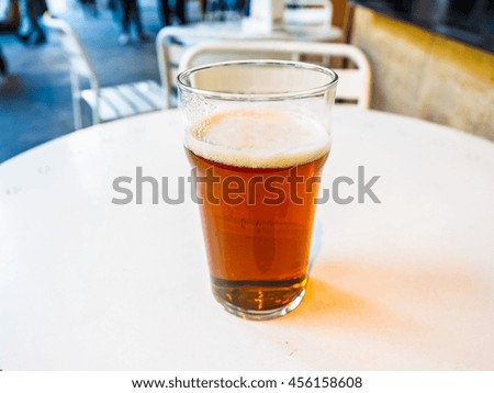 High dynamic range (HDR) Pint of British ale on a pub table - selective focus on beer over blurred background