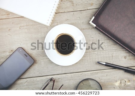 smartphone, diary, glasses, and coffee  on wooden table
