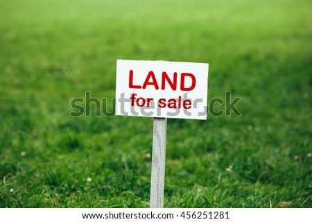 land for sale sign against trimmed lawn background