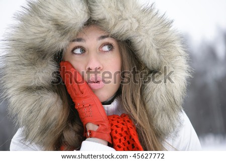 Surprised girl in the park, gloved hands are on her cheeks
