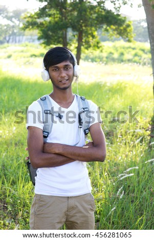indian male college student listening to music outdoor