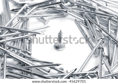 Concept photo of screw surrounded by nails on white