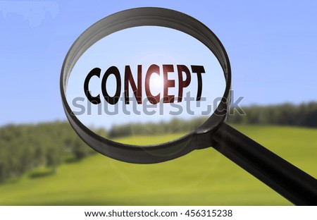 Magnifying glass with the word concept on blurred nature background