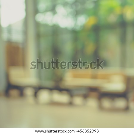 vintage tone blur image of living room with table and sofa for background usage.