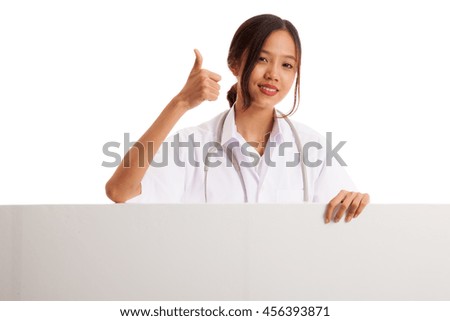 Young Asian female doctor show thumbs up  behind blank white billboard  isolated on white background