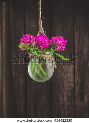 Flowers in jars on a string.