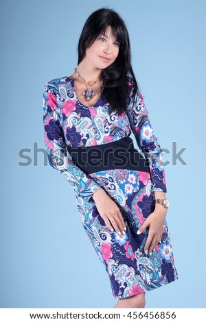 Beautiful young girl posing in street clothes on blue background.Isolated studio portrait