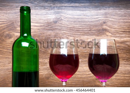 Wine glass and bottle on a wooden background