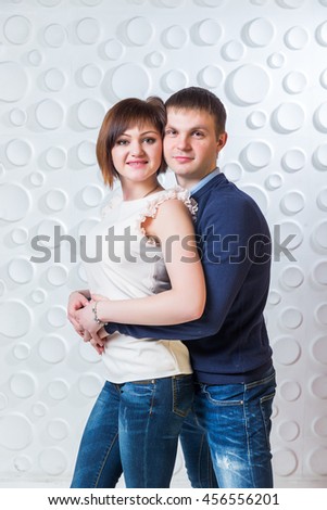 Russian couple embracing on a wall background with bubbles in the studio