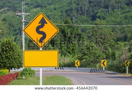 Winding Road Sign on asphalt road

