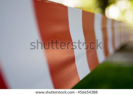 Red and white warning tape stretched across a blurred background